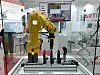 Roboterapplikation am Artiminds-Stand auf der Automatica 2023: Gelber Roboterarm montiert Teile an Motoren