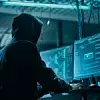 Hacker in Hoodie vor Bildschirmen