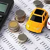 Spielzeuautos stehen neben Münzen und Taschenrechner