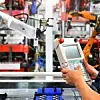 Ingenieur kontrolliert Roboterarm beim Verpackungsprozess von Lagern in der Automobilindustrie.
