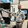 Andrea Alboni von Universal Robots zeigt eine Demo-Anlage mit Cobot/kollaborativem Roboter und Werkzeugmaschine auf der Automatica 2023.