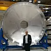 COO Bernd Beschorner vor einem Bauteil für Ariane 6.