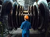 Bauarbeiter mit orangem Helm vor Gasturbine