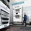 Mann steht an einer Hydrogen-Tankstelle und möchte einen LKW tanken.
