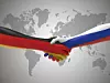 Eine Hand in Deutschlandfarben und eine in Russlandfarben geben sich die Hand.