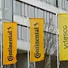 Zwei orangenfarbene Flaggen von Continental stehen neben einer gelben Fahne von Vitesco.