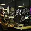 Industry 4.0 Modern Factory: Facility Operator Controls Workshop Production Line, Uses Computer with Screens Showing Complex UI of Machine Operation Processes, Controllers, Machinery Blueprints