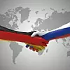 Eine Hand in Deutschlandfarben und eine in Russlandfarben geben sich die Hand.