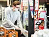 Ein Kassierer im Supermarkt arbeitet unter verstärkten Schutzmaßnahmen