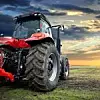 Agricultural tractor working in the field at sunset background
