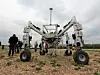 Mehrere Personen stehen auf einem Feld bei dem Roboter für Unkrautbekämpfung