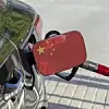 Ein Auto, das die chinesische Flagge auf dem Tankdeckel trägt, wird mit einer Zapfpistole betankt.