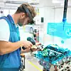Ein Mitarbeiter trainiert Verschraubungen am Zylinderkopf eines Motors – die Augmented-Reality-Brille unterstützt ihn dabei