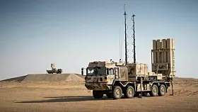 Zu einer „Standardeinheit“ des Systems IRIS-T SLM gehören unter anderem drei Launcherfahrzeuge (eines im Vordergrund) und ein Mittelbereichsradar TRML-4D (hinten).