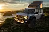 Ford Bronco Raptor in wild terrain, equipped with expedition gear and a roof tent
