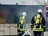 Zwei Feuerwehrmänner löschen Brand in Schutzkleidung