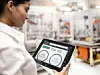Eine Mitarbeiterin überwacht den Maschinenzustand in der Fertigung per Tablet