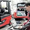 Servicetechniker fragt via Laptop Servicedaten eines Gabelstaplers ab.