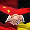 Chinesische und deutsche Flagge nebeneinander. Händeschütteln davor.