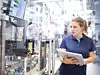 Eine Bosch-Mitarbeiterin beim Bedienen einer Maschine mithilfe eines Tablets