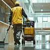 Janitor with cleaning cart working in a modern building