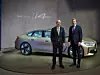 BMW-Chef Oliver Zipse und Finanzvorstand Nicolas Peter stehen vor einem BMW i4.