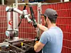 Werker arbeitet mit Cobot zusammen
