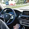 BMW Testfahrer in einem selbstfahrenden Auto, seine Hände sind nicht am Steuer