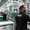 Mehrere Werker arbeiten in der Technologiefabrik Scharnhausen von Festo an Produkten in Losgröße 1 – sowohl vollautomatisiert als auch per Handmontage.