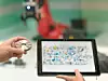 Ein digitaler Zwilling am Tablet gibt den automatisierten Montageprozess mittels Roboter wieder