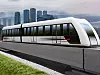 Die Magnetschwebebahn TSB fährt auf einer Trasse vor der Skyline einer asiatischen Großstadt