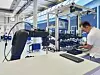Arbeiter an einem Montagearbeitsplatz mit einem Cobot