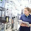 Eine Bosch-Mitarbeiterin beim Bedienen einer Maschine mithilfe eines Tablets
