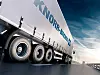 Seitenansicht eines fahrenden LKW mit Werbung von Knorr Bremse auf Plane
