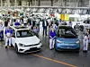 VW Mitarbeiter aus Zwickau stehen mit dem Golf und dem Id3 im Werk