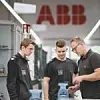 Ein ABB-Mitarbeiter erklärt zwei Auszubildenden etwas.