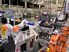 Kuka-Roboter im Ford Werk. Ein Beschäftigter arbeitet damit
