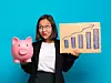 Eine Geschäftsfrau steht vor blauem Hintergrund und hält in der einen Hand ein Sparschwein und in der anderen ein Papier mit einer Statistik darauf.