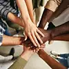 Verschiedene Menschen unterschiedlicher Hautfarben legen ihre Hände aufeinander
