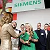 Das Bild zeigt das Sieger-Werk von Siemens zusammen mit Moderatorin Katrin Müller-Hohenstein.