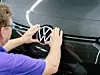 VW Logo wird im Werk von einem Werker angebracht