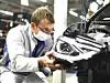 Ein Volkswagen-Mitarbeiter arbeitet an einem Fahrzeug
