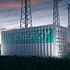 Energy storage Container auf einer Wiese mit Strommasten im Hintergrund