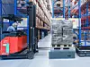 Autonome mobile Roboter transportieren Paletten vom Depot ins Lager, bemannte Hochstapler übernehmen.