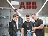 Ein ABB-Mitarbeiter erklärt zwei Auszubildenden etwas.