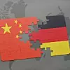 Puzzle mit den Nationalflaggen von China und Deutschland auf einem Weltkartenhintergrund.