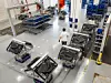 Mitarbeiter läuft bei der modularen Montage bei Audi zwischen Fahrerlosen Transportsystemen