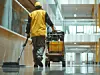 Janitor with cleaning cart working in a modern building