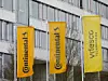 Zwei orangenfarbene Flaggen von Continental stehen neben einer gelben Fahne von Vitesco.
