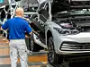 Ein Mitarbeiter montiert einen an einem VW Golf 8 im Volkswagen-Werk Wolfsburg.